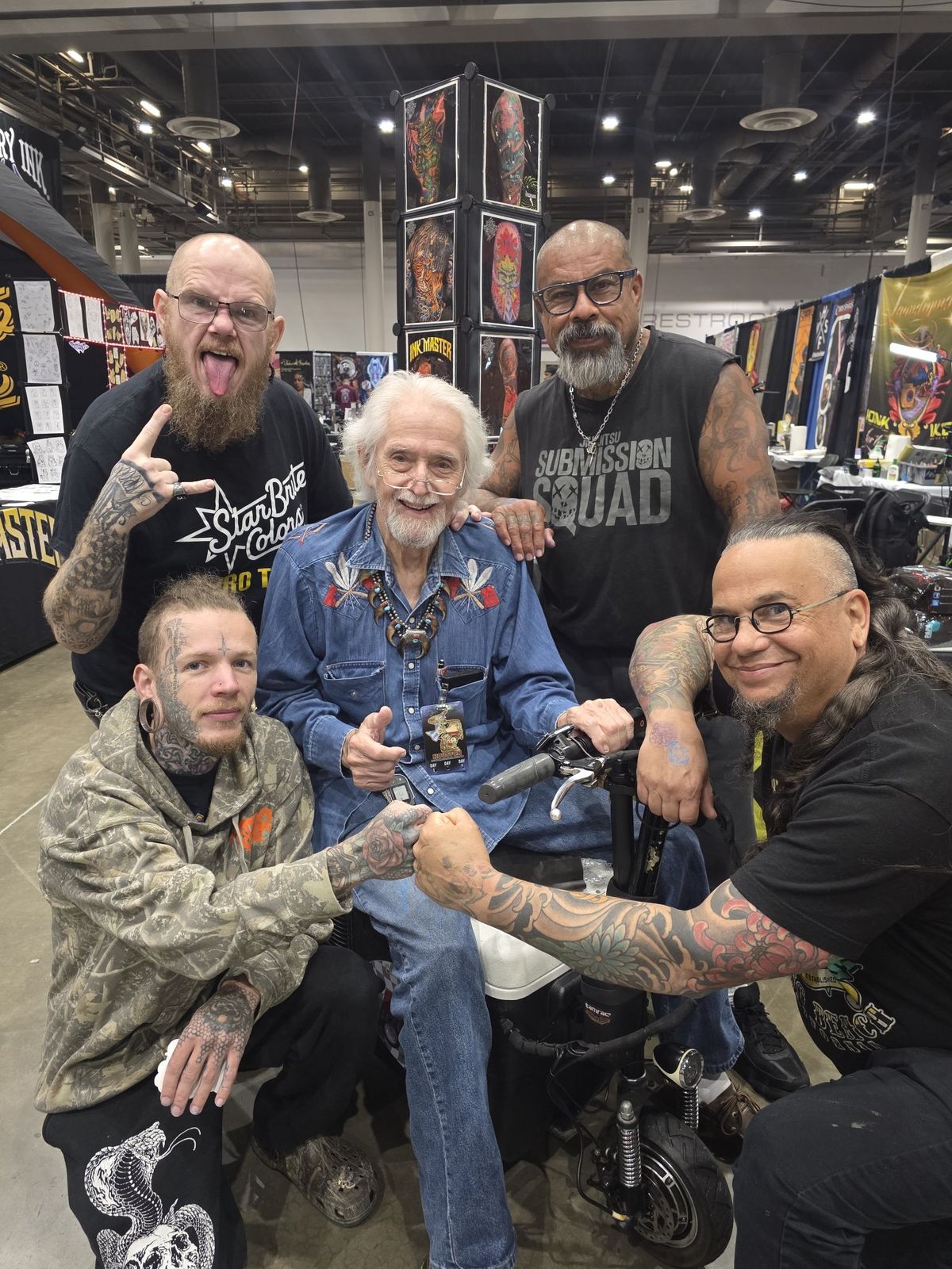 Tank with a group of fellow artists at a tattoo convention
