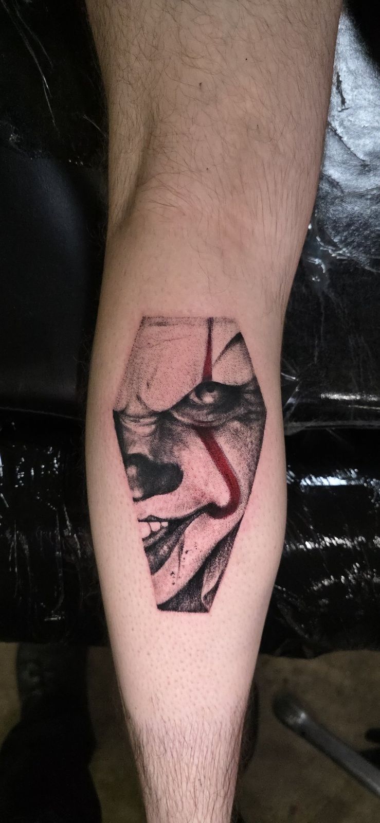 Coffin-shaped black-and-gray portrait tattoo with a narrow red accent