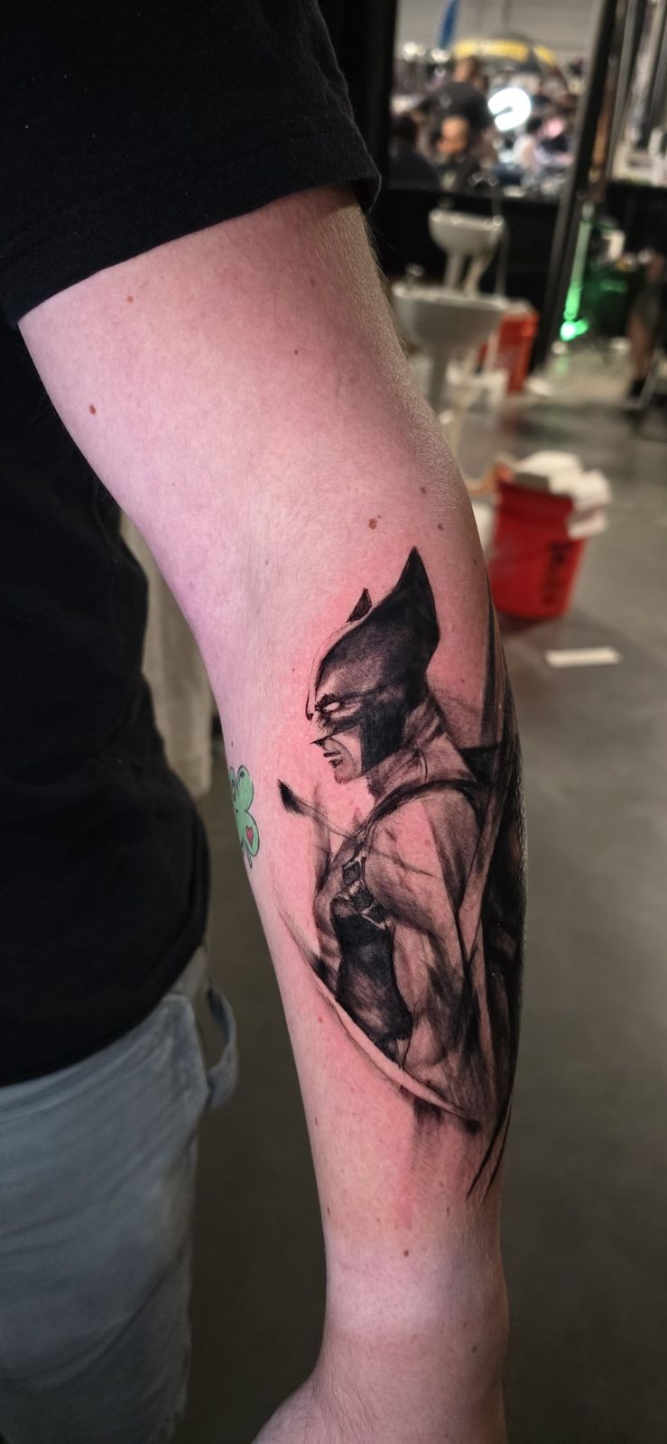 Black-and-gray Wolverine portrait tattoo wrapping the forearm
