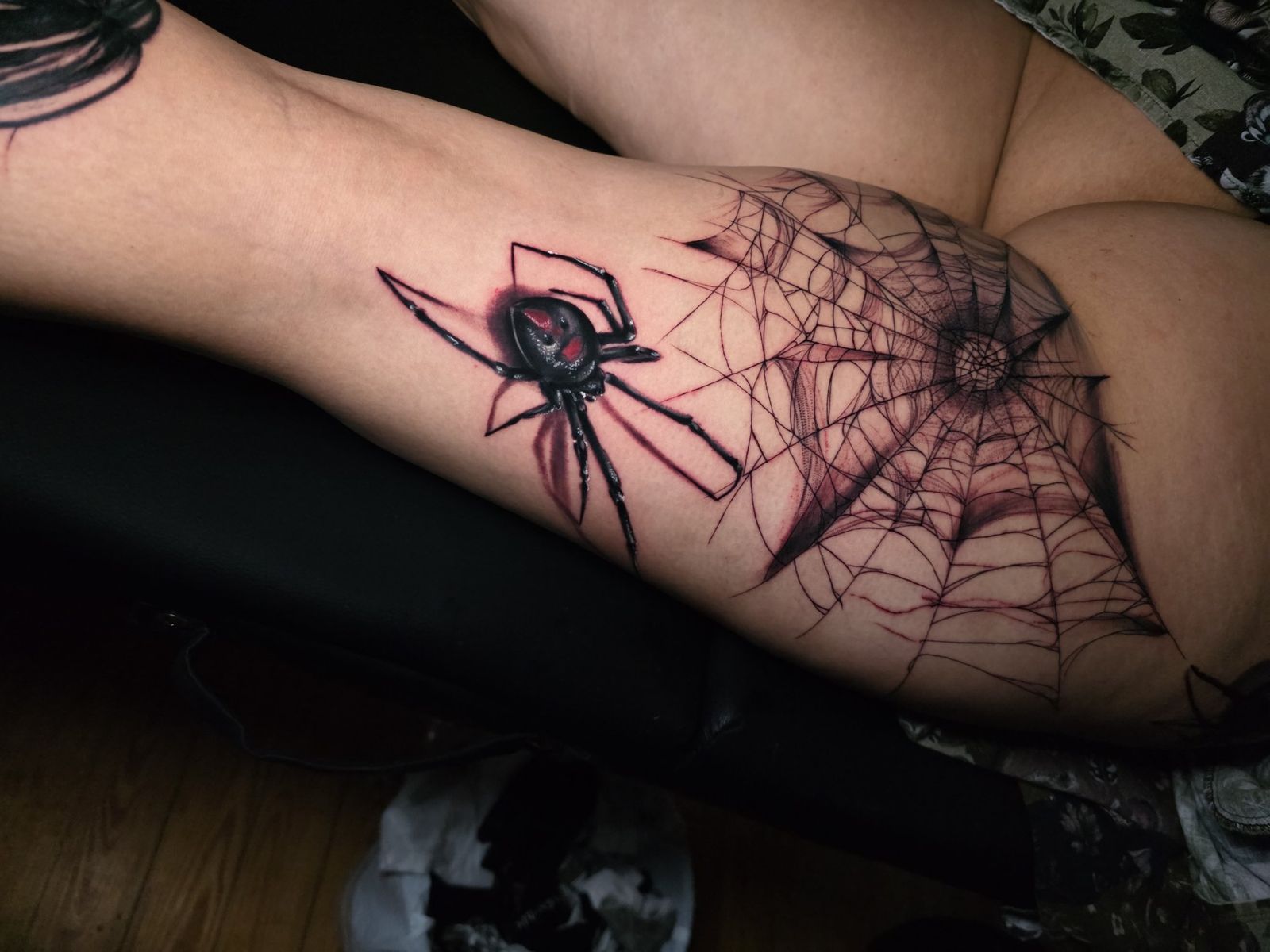 Black widow spider and web tattoo spanning the thigh