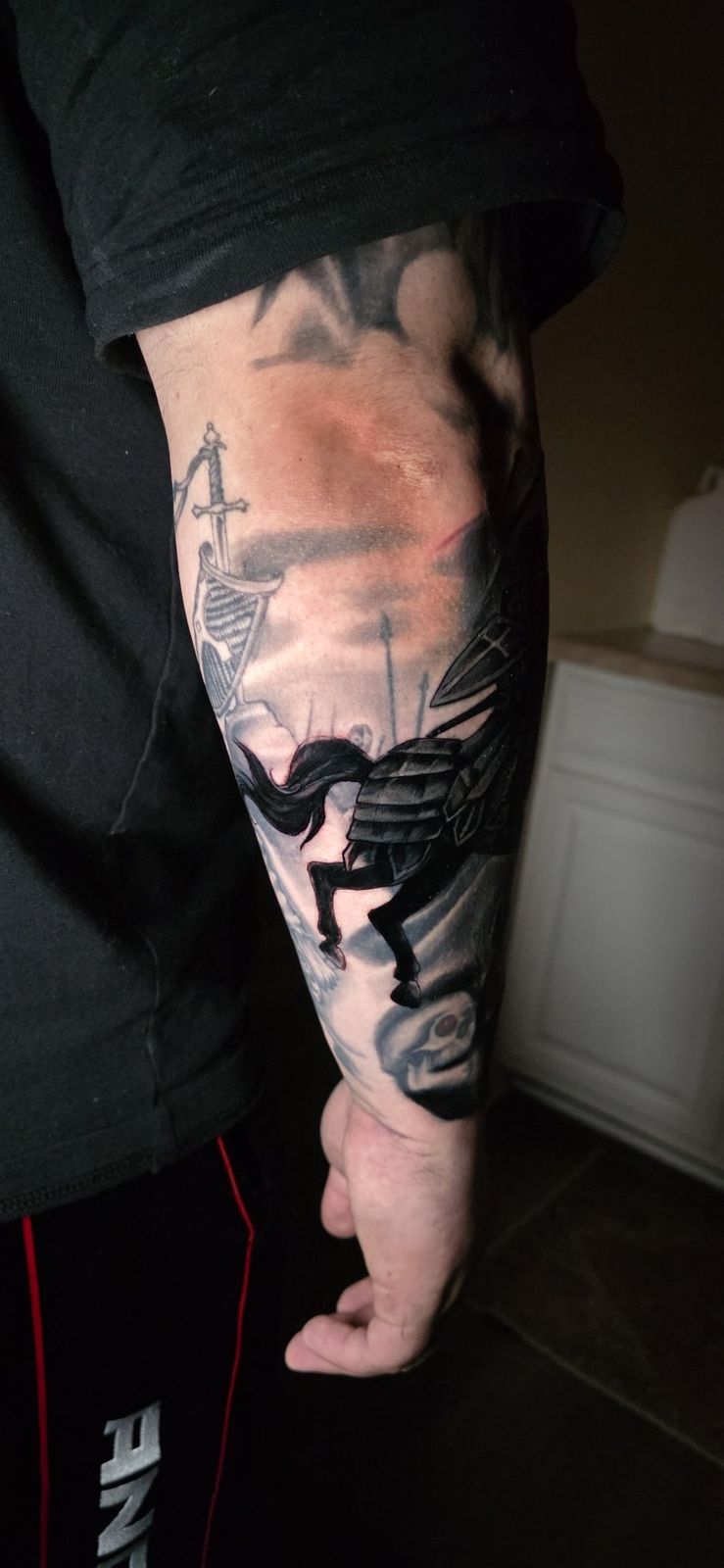 Alternate view of a black-and-gray knight on horseback forearm tattoo