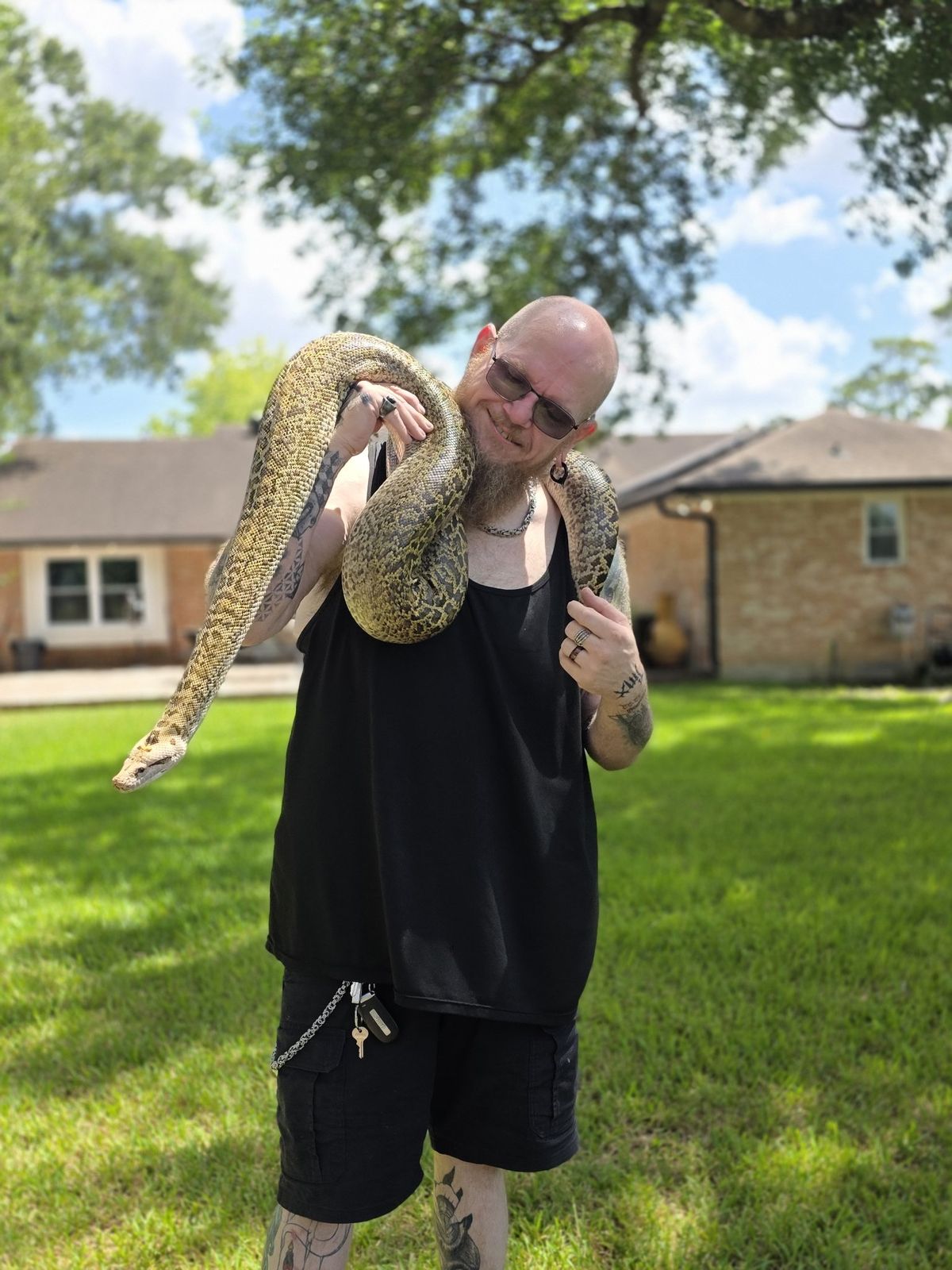 Tank smiling with a giant python draped across his shoulders