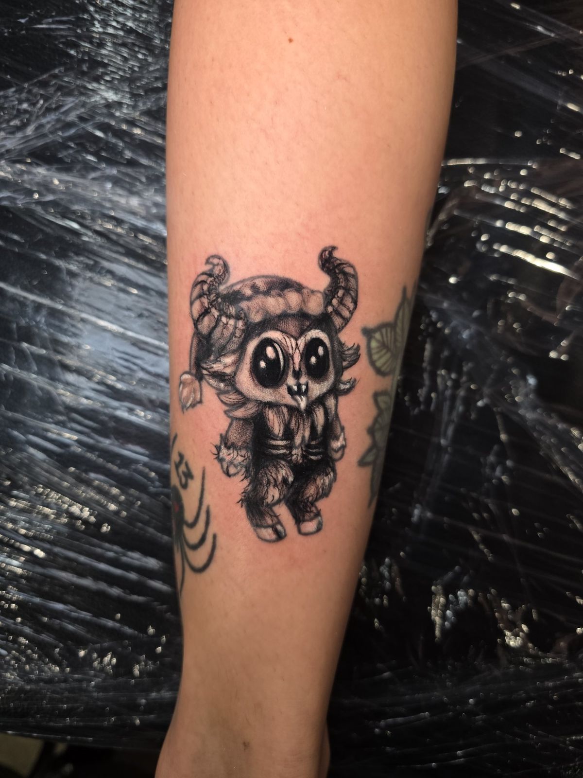 Alternate view of a shaded chibi horned demon tattoo on the forearm