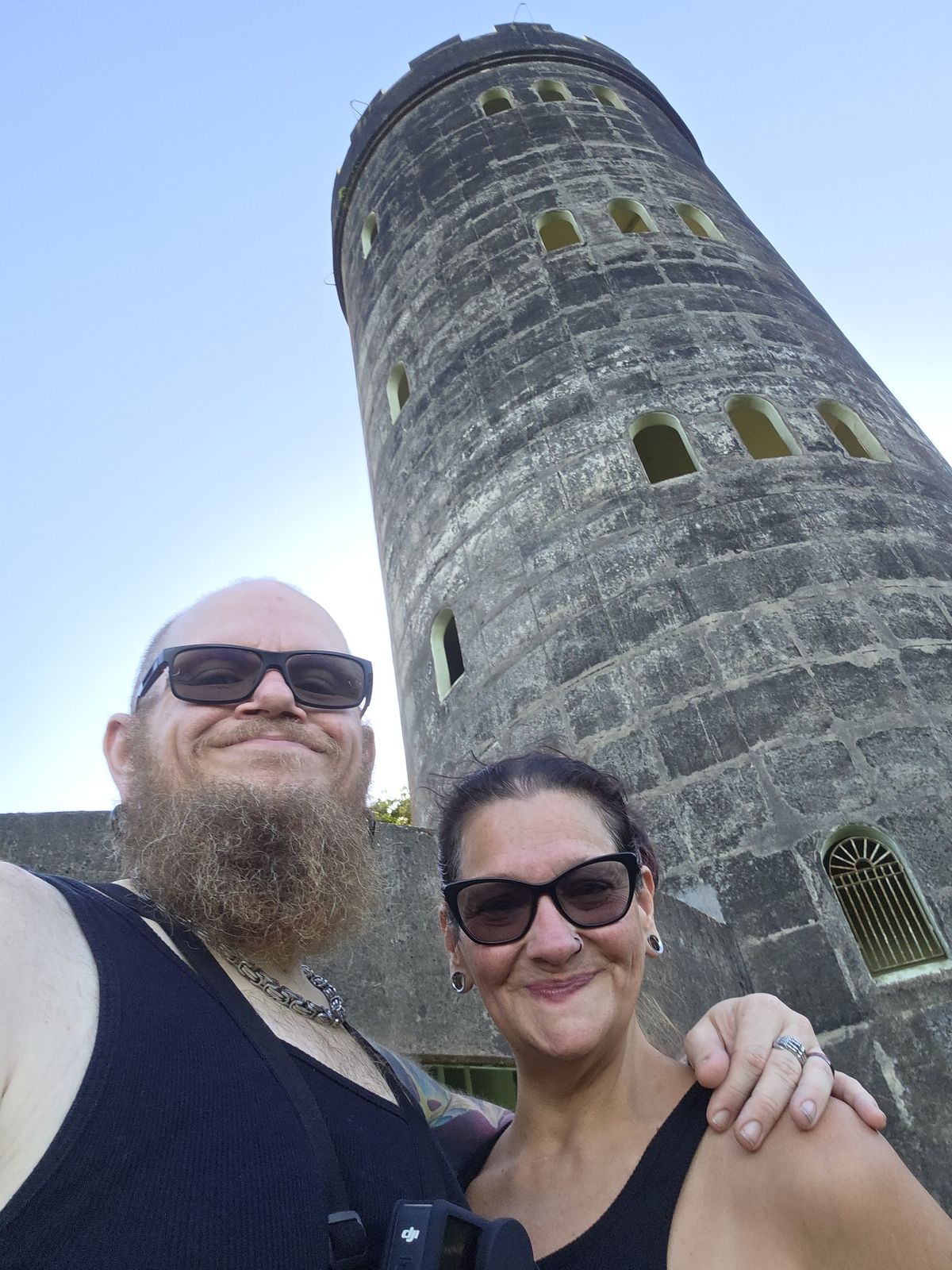 Tank and Sandra smiling together in front of a stone tower