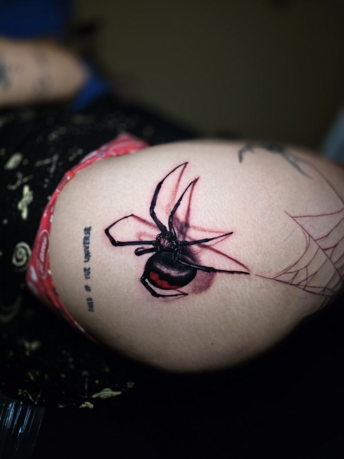 Black widow spider tattoo with a red hourglass detail