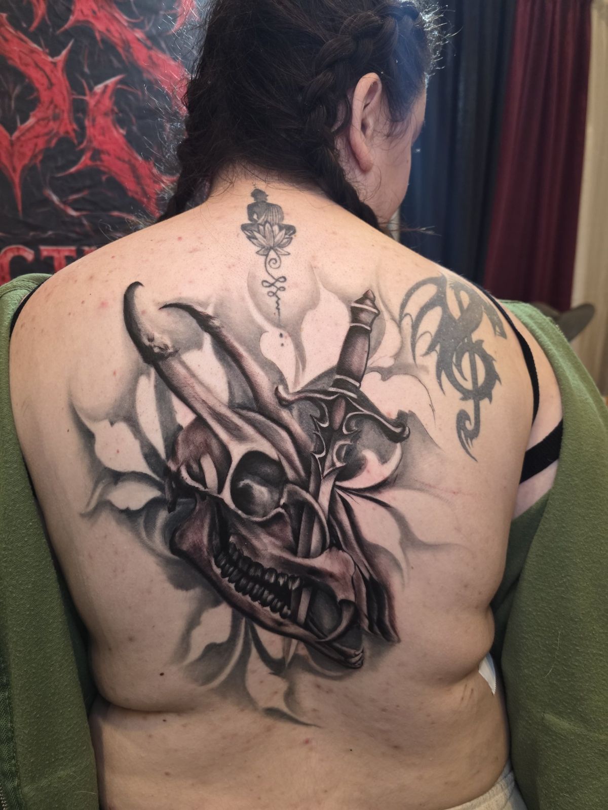 Large black-and-gray demon skull and dagger composition across the back